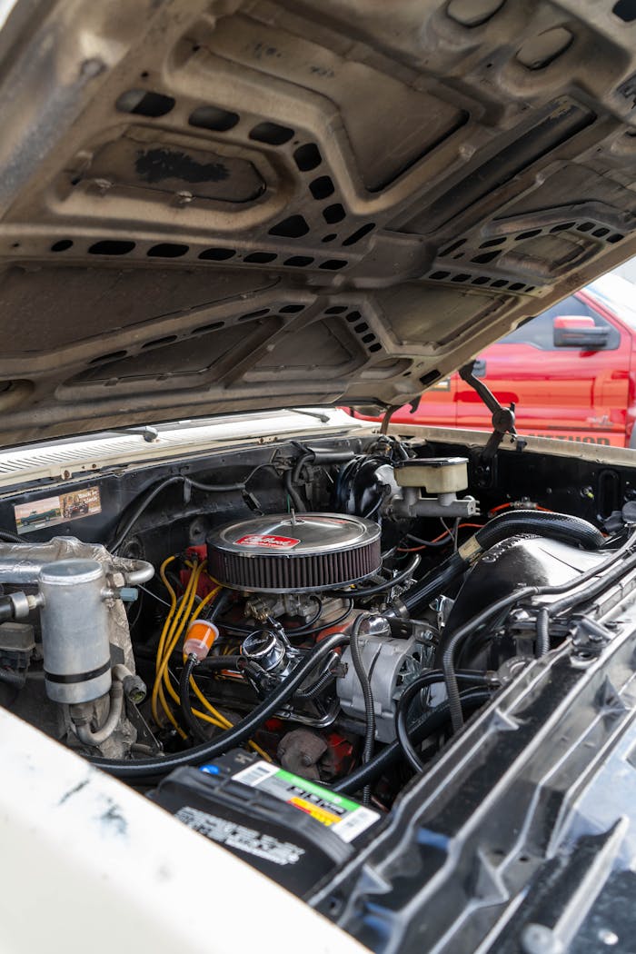 our-services-2 Detailed look at an open hood car engine bay showcasing mechanical components.